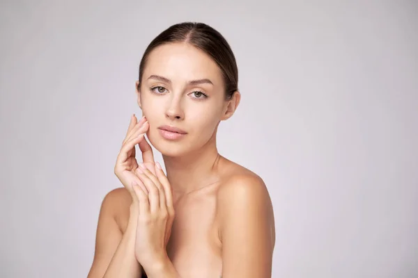 Beautiful Young Woman with Clean Fresh Skin standing over light grey background — Stock Photo, Image