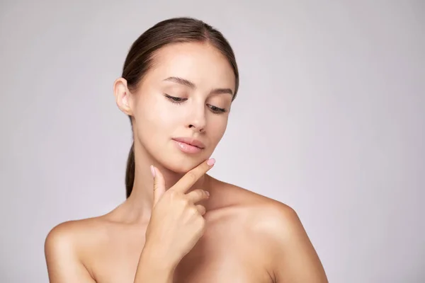 Beautiful Young Woman with Clean Fresh Skin standing over light grey background — Stock Photo, Image