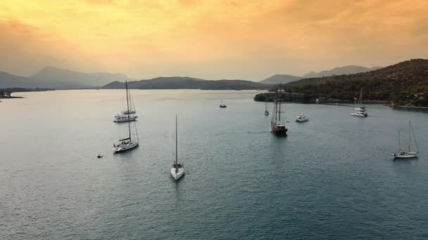 Catamarã e vela Iates ancorados na baía em águas profundas do mar azul ao nascer do sol — Vídeo de Stock