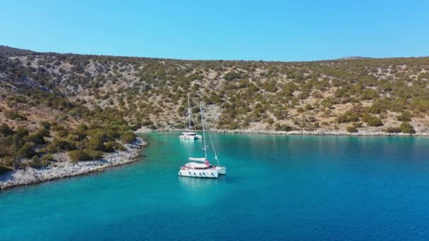 Catamarán y vela Yates anclados a raya en aguas profundas de mar azul al amanecer — Vídeos de Stock