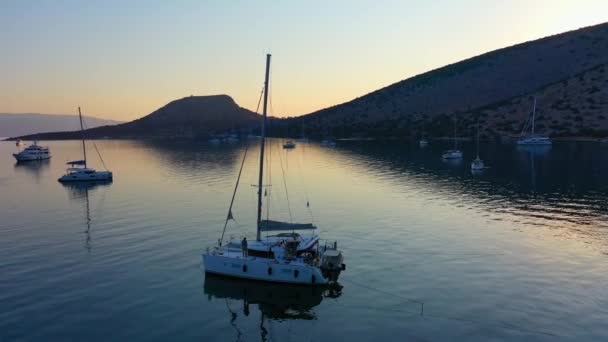 Catamarano e vela Yacht ancorati a bada su acque blu intenso all'alba — Video Stock