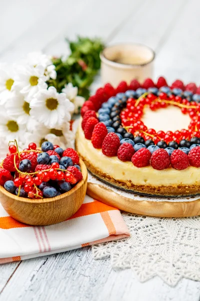 Tarta de queso con frambuesa y arándanos sobre mesa de madera —  Fotos de Stock