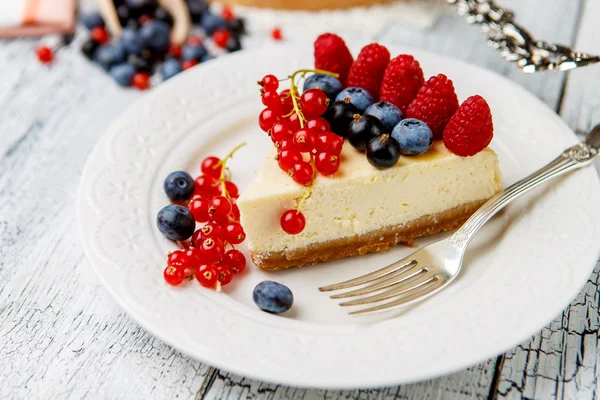 Tarta de queso con frambuesa y arándanos sobre mesa de madera —  Fotos de Stock