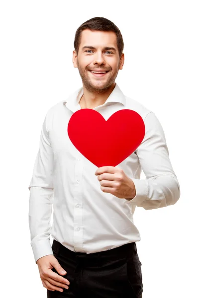Mladý muž nosí červenou kartu ve tvaru srdce — Stock fotografie