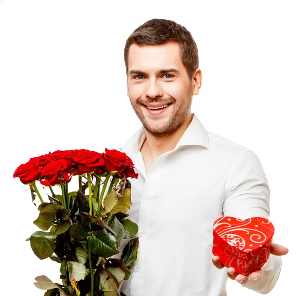 Jovem carrega caixa em forma de coração e flores — Fotografia de Stock