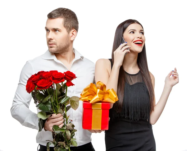 Junges schönes Paar mit Geschenk isoliert auf weiß — Stockfoto