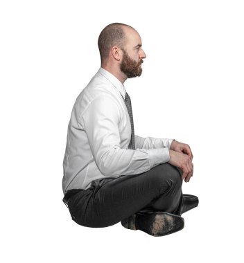 Bacak bacak üstüne atmış bir iş adamı, beyaz üzerine oturmuş kenarda oturuyor..