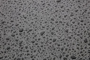 Siyah metalik yüzeye su damlası