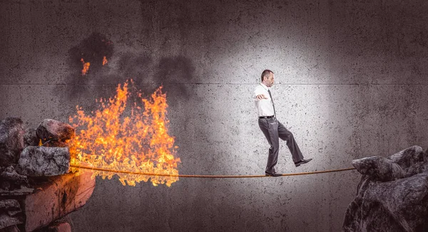 businessman walks in balance on a burning rope. danger concept.