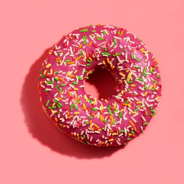 Polvilhado delicioso donut no fundo rosa Imagens De Bancos De Imagens Sem Royalties