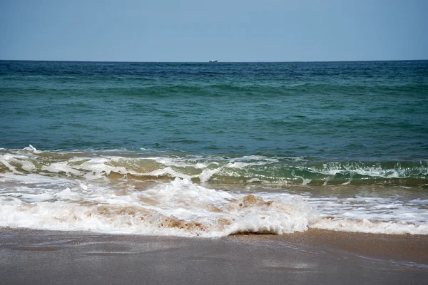 Vagues mousseuses sur la plage . — Photo