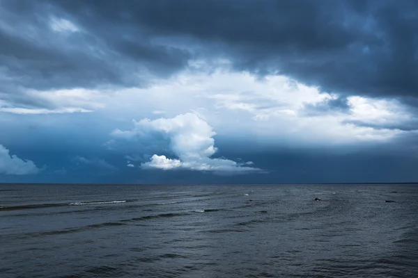 Weiße Wolken und dunkles Meer. — Stockfoto