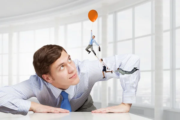 Big businessman peeping from under table — Stock Photo, Image