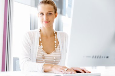 Çekici ofis çalışanı masada oturuyor.