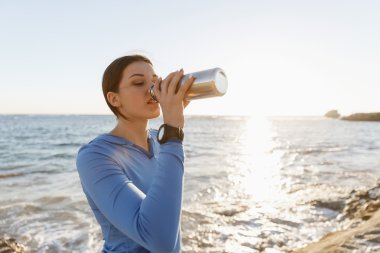 Kumsalda su içen kadın