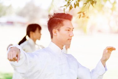 Yakışıklı adam Thai Chi yapıyor.