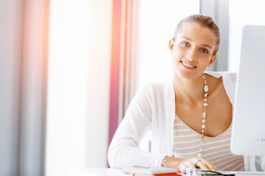 Çekici ofis çalışanı masada oturuyor.