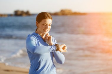 Kalp atış hızı monitörünü plajda çalışan kadınla Runner