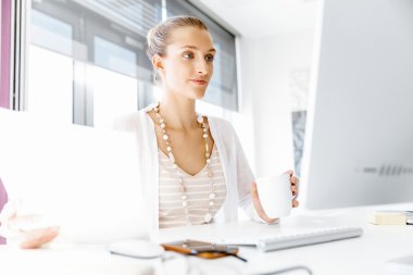 Çekici ofis çalışanı masada oturuyor.