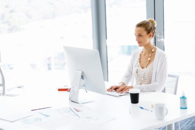 Çekici ofis çalışanı masada oturuyor.