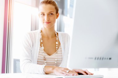 Çekici ofis çalışanı masada oturuyor.