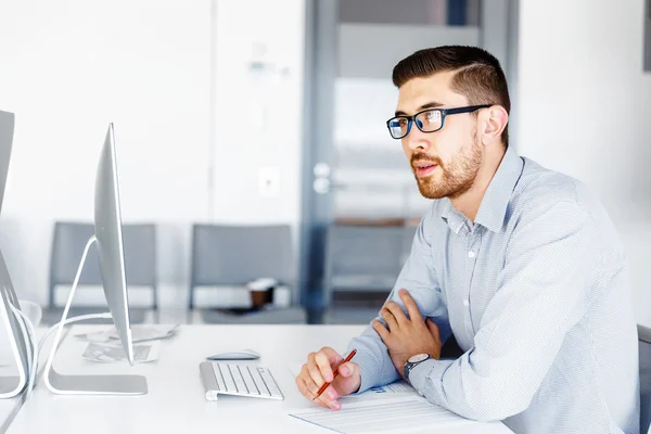 Männliche Büroangestellte sitzt am Schreibtisch — Stockfoto