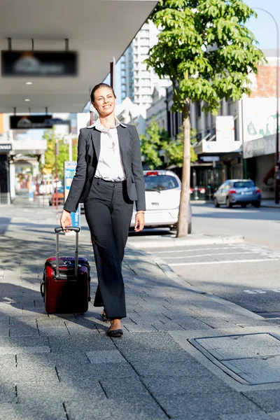 Mujer de negocios tirando del bolso de la maleta caminando en la ciudad —  Fotos de Stock