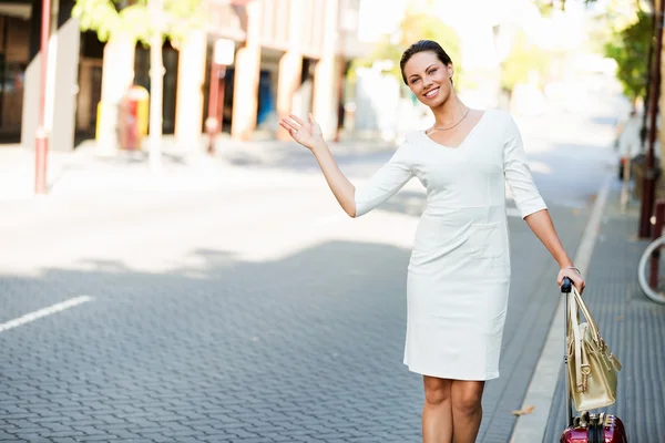 Femme d'affaires tirant sac à valise marche dans la ville — Photo