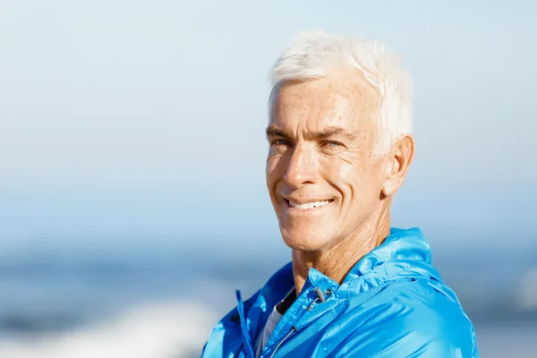 Человек, стоящий на пляже в спортивной одежде — стоковое фото