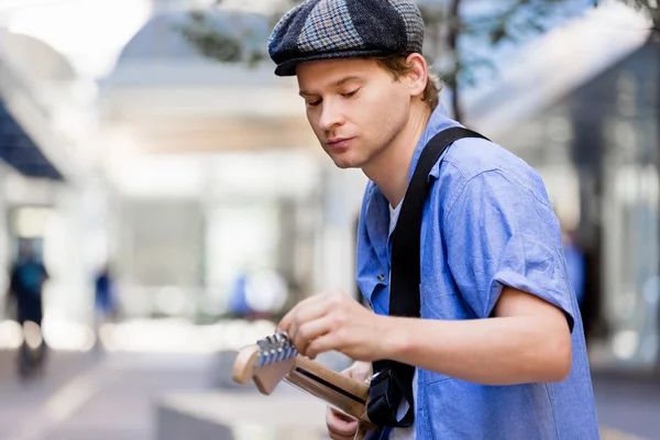 Young musician with guitar in city — Stock Photo, Image