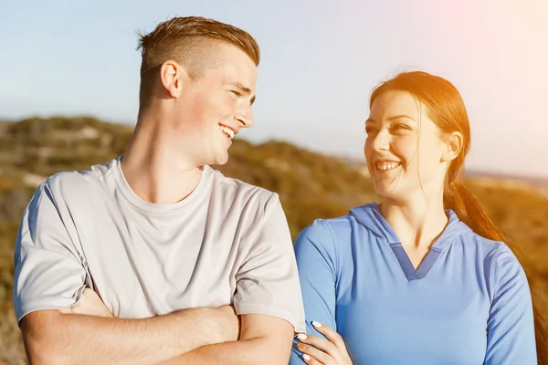 Young couple on beach in sportwear — Stock Photo, Image