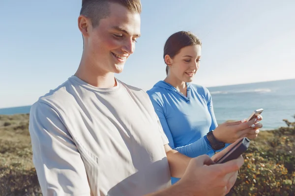 Jeune couple avec smartphones en plein air — Photo