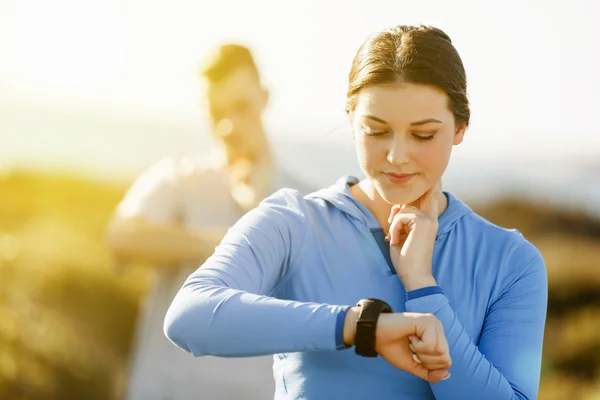 Loper vrouw met hartslagmeter uitgevoerd op strand — Stockfoto