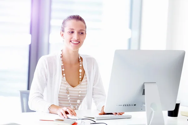 Attractive office worker sitting at desk — Stock Photo, Image