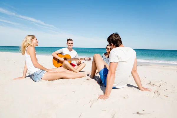 Hermosos jóvenes con guitarra en la playa — Foto de Stock