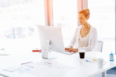 Çekici ofis çalışanı masada oturuyor.