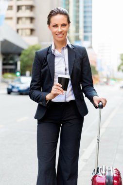 Şehirde yürüyüş çanta çekerek iş kadını