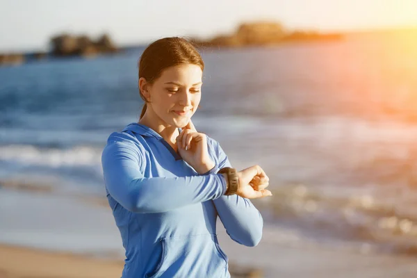 Runner donna con cardiofrequenzimetro in esecuzione sulla spiaggia — Foto Stock