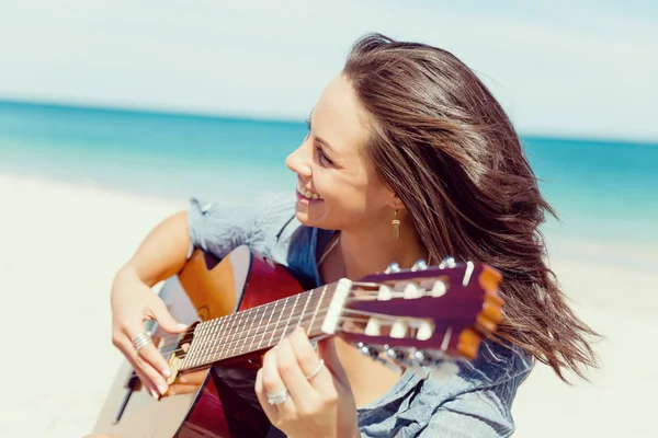 Bella giovane donna che suona la chitarra sulla spiaggia — Foto Stock