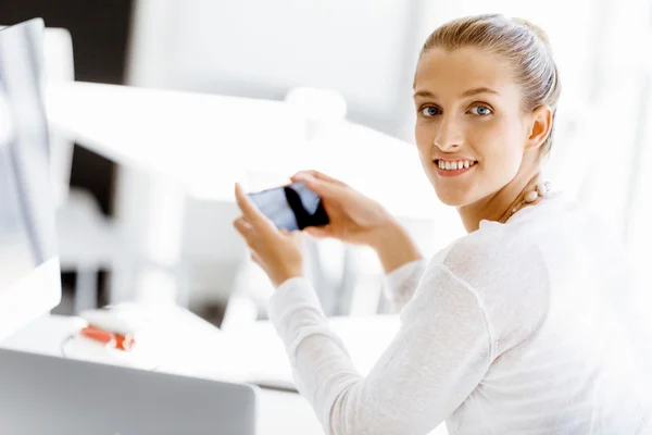 Attractive office worker sitting at desk — Stock Photo, Image