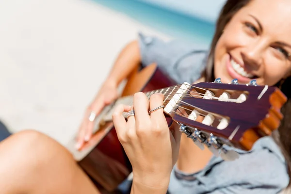 Piękna młoda kobieta gra na gitarze na plaży — Zdjęcie stockowe