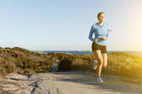 Sport runner joggen op strand uit te werken — Stockfoto