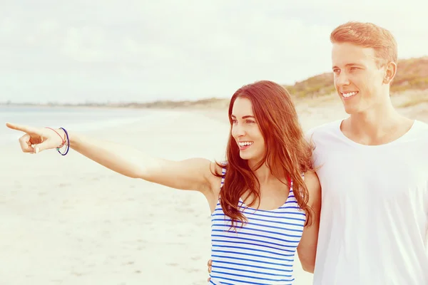 Jovem feliz e mulher casal juntos andando em uma praia — Fotografia de Stock