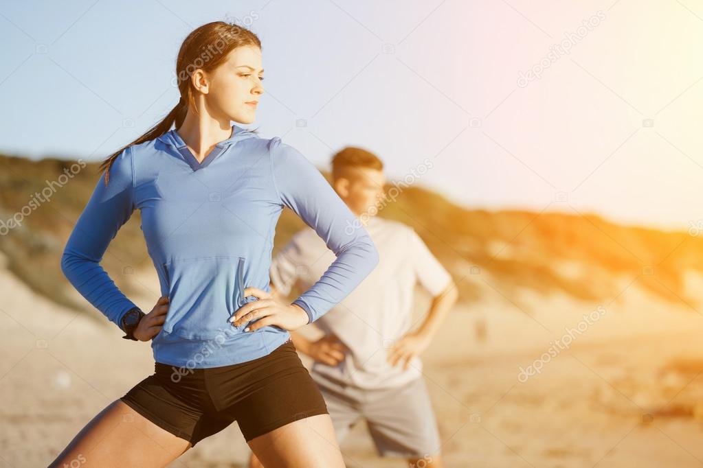 Young couple on beach training together