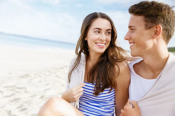 Romantique jeune couple assis sur la plage — Photo