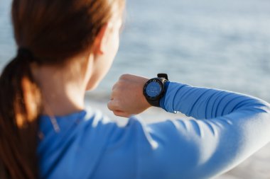 Kalp atış hızı monitörünü plajda çalışan kadınla Runner