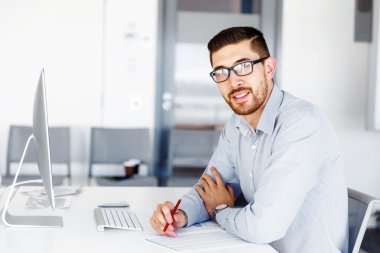 Masa başında oturan erkek ofis çalışanı