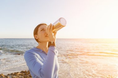 Kumsalda su içen kadın