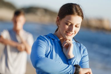 Kalp atış hızı monitörünü plajda çalışan kadınla Runner