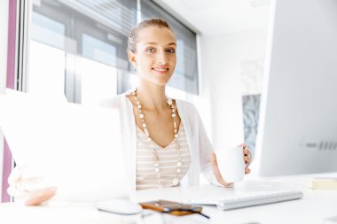 Çekici ofis çalışanı masada oturuyor.